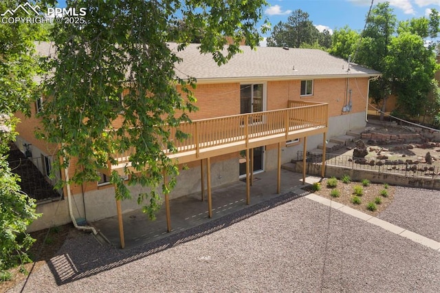 1411 Acacia Dr, Colorado Springs, CO 80907 - back of property with a patio area, a deck, brick siding, and roof with shingles