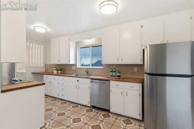 1411 Acacia Dr, Colorado Springs, CO 80907 - kitchen with appliances with stainless steel finishes, independent washer and dryer, butcher block counters, and white cabinets