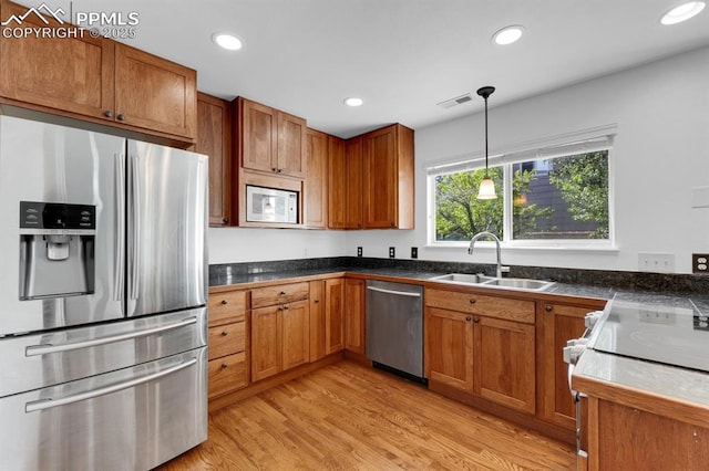 5105 Stellar Dr, Colorado Springs, CO 80923 - kitchen featuring appliances with stainless steel finishes, brown cabinets, light wood-type flooring, and recessed lighting