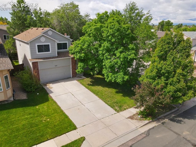 5105 Stellar Dr, Colorado Springs, CO 80923 - view of front of house featuring brick siding, concrete driveway, a garage, and a front lawn