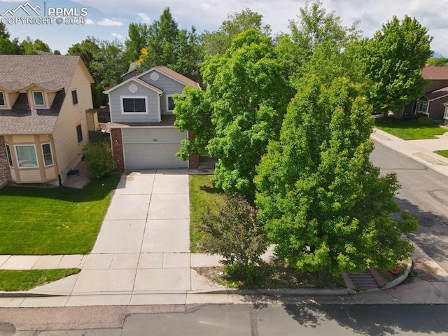 5105 Stellar Dr, Colorado Springs, CO 80923 - view of property hidden behind natural elements with driveway, brick siding, a garage, and a front yard