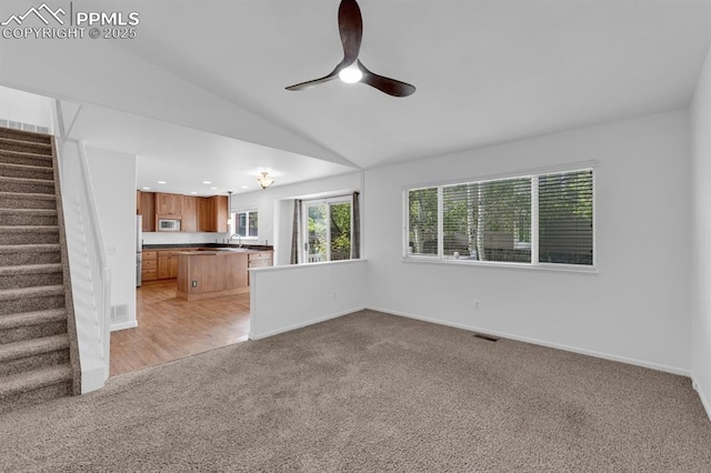 5105 Stellar Dr, Colorado Springs, CO 80923 - unfurnished living room featuring light carpet, ceiling fan, lofted ceiling, and stairway