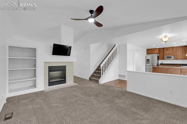 5105 Stellar Dr, Colorado Springs, CO 80923 - unfurnished living room with carpet floors, stairs, a fireplace, lofted ceiling, and a ceiling fan