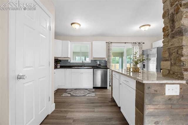 519 Crest St, Fountain, CO 80817 - kitchen with appliances with stainless steel finishes, white cabinets, dark wood-type flooring, and decorative backsplash