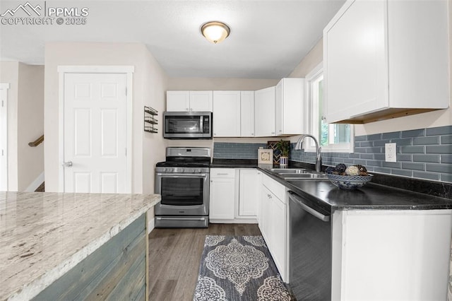 519 Crest St, Fountain, CO 80817 - kitchen with appliances with stainless steel finishes, dark wood finished floors, white cabinetry, and tasteful backsplash