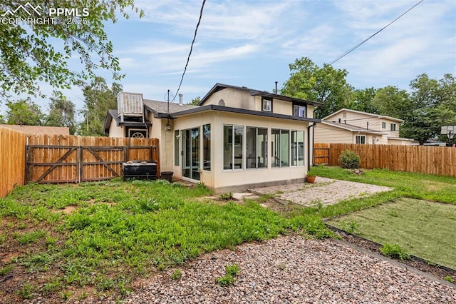 519 Crest St, Fountain, CO 80817 - back of property featuring a fenced backyard, a sunroom, stucco siding, and a gate
