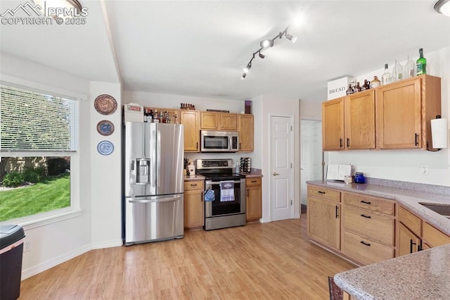 3320 Chestnut Glen Ln, Colorado Springs, CO 80918 - kitchen featuring stainless steel appliances, light wood-type flooring, light countertops, baseboards, and rail lighting