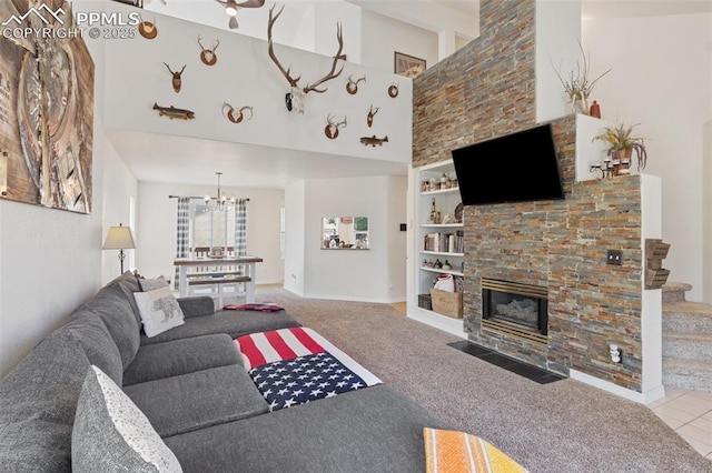 3320 Chestnut Glen Ln, Colorado Springs, CO 80918 - carpeted living room with built in shelves, a stone fireplace, a chandelier, stairway, and a high ceiling