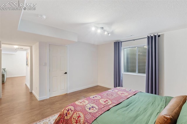 3320 Chestnut Glen Ln, Colorado Springs, CO 80918 - bedroom featuring wood finished floors, a textured ceiling, and baseboards