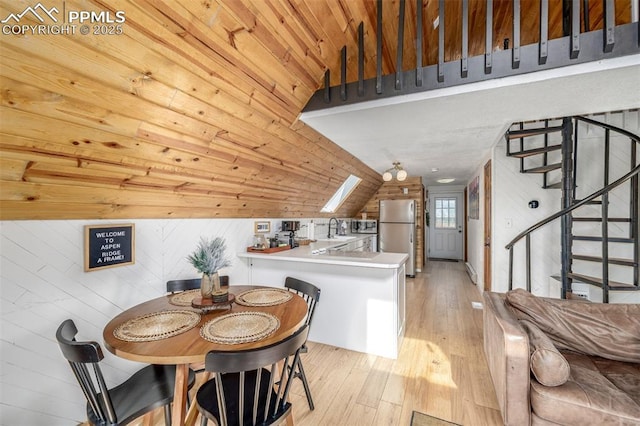 860 Golden Cycle Cir, Cripple Creek, CO 80813 - dining space with stairs, light wood-type flooring, and lofted ceiling