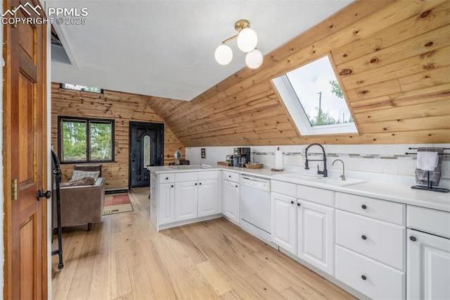 860 Golden Cycle Cir, Cripple Creek, CO 80813 - kitchen featuring white dishwasher, light wood-style flooring, a skylight, white cabinetry, and a peninsula