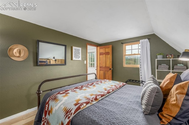 860 Golden Cycle Cir, Cripple Creek, CO 80813 - bedroom featuring wood finished floors, lofted ceiling, and a textured wall