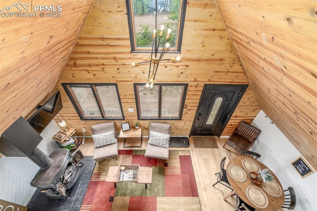 860 Golden Cycle Cir, Cripple Creek, CO 80813 - living area featuring wood walls, wood finished floors, a chandelier, and high vaulted ceiling