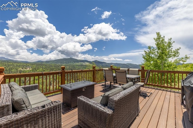 860 Golden Cycle Cir, Cripple Creek, CO 80813 - wooden terrace with outdoor dining space, a mountain view, and an outdoor living space