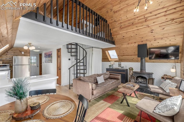 860 Golden Cycle Cir, Cripple Creek, CO 80813 - living room with wooden walls, a wood stove, lofted ceiling, stairway, and wood finished floors