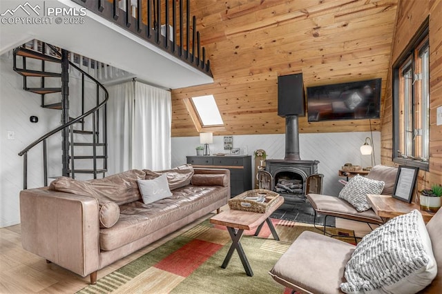 860 Golden Cycle Cir, Cripple Creek, CO 80813 - living area featuring a skylight, stairway, wood finished floors, wood walls, and a wood stove