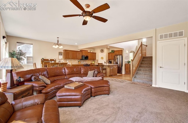 10702 Black Kettle Way, Colorado Springs, CO 80908 - living room featuring a ceiling fan, stairway, light carpet, and a chandelier