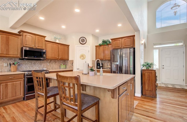 10702 Black Kettle Way, Colorado Springs, CO 80908 - kitchen featuring stainless steel appliances, light countertops, a kitchen breakfast bar, light wood-style floors, and plenty of natural light