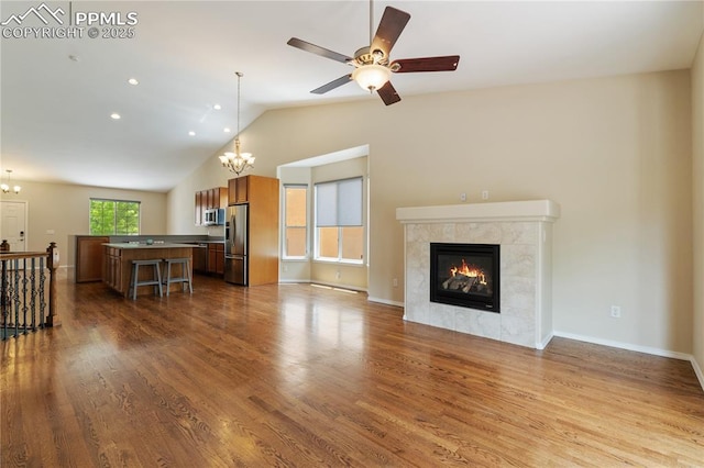 4410 Campus Bluffs Ct, Colorado Springs, CO 80918 - living area with a chandelier, a fireplace, dark wood-type flooring, vaulted ceiling, and a ceiling fan