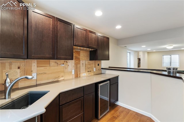 4410 Campus Bluffs Ct, Colorado Springs, CO 80918 - kitchen featuring wine cooler, light wood-style floors, dark brown cabinetry, recessed lighting, and light countertops