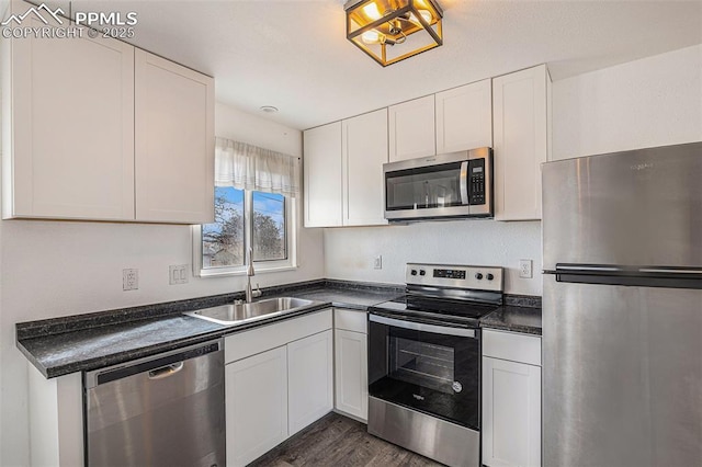 140 Schirra Pl, Pueblo, CO 81001 - kitchen with stainless steel appliances, a sink, dark countertops, and dark wood finished floors