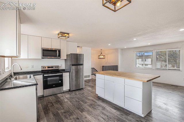 140 Schirra Pl, Pueblo, CO 81001 - kitchen featuring appliances with stainless steel finishes, a sink, white cabinets, recessed lighting, and dark wood finished floors