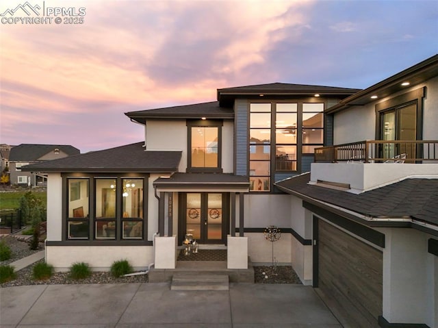 10423 Bergan Peak Ct, Colorado Springs, CO 80924 - back of house at dusk with a balcony and stucco siding