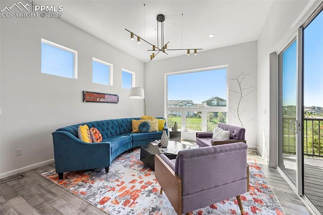 10423 Bergan Peak Ct, Colorado Springs, CO 80924 - living room with wood finished floors, healthy amount of natural light, a chandelier, and recessed lighting