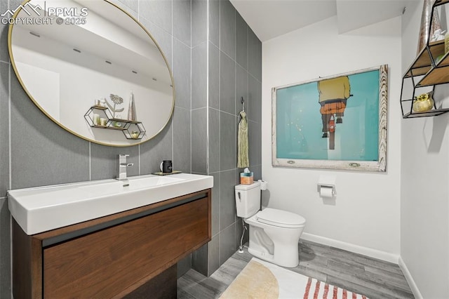 10423 Bergan Peak Ct, Colorado Springs, CO 80924 - bathroom featuring vanity, wood finished floors, and tile walls