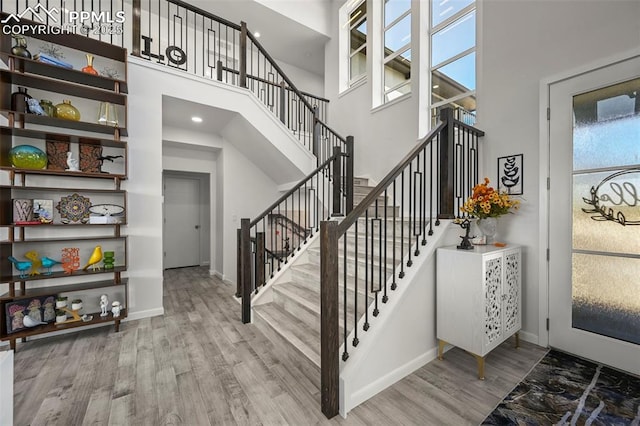 10423 Bergan Peak Ct, Colorado Springs, CO 80924 - stairs with a towering ceiling, wood finished floors, and recessed lighting
