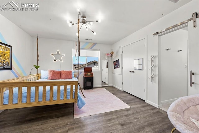 10423 Bergan Peak Ct, Colorado Springs, CO 80924 - bedroom with a barn door, wood finished floors, a chandelier, and a closet