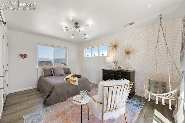 10423 Bergan Peak Ct, Colorado Springs, CO 80924 - bedroom featuring a chandelier, wallpapered walls, wood finished floors, and an accent wall