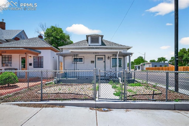 1301 Cypress St, Pueblo, CO 81004 - view of front facade with covered porch, a gate, a fenced front yard, roof with shingles, and stucco siding