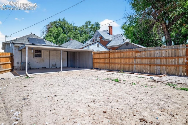 1301 Cypress St, Pueblo, CO 81004 - back of property featuring a patio, a fenced backyard, solar panels, and stucco siding