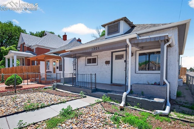 1301 Cypress St, Pueblo, CO 81004 - view of front of home featuring a porch, stucco siding, and roof with shingles