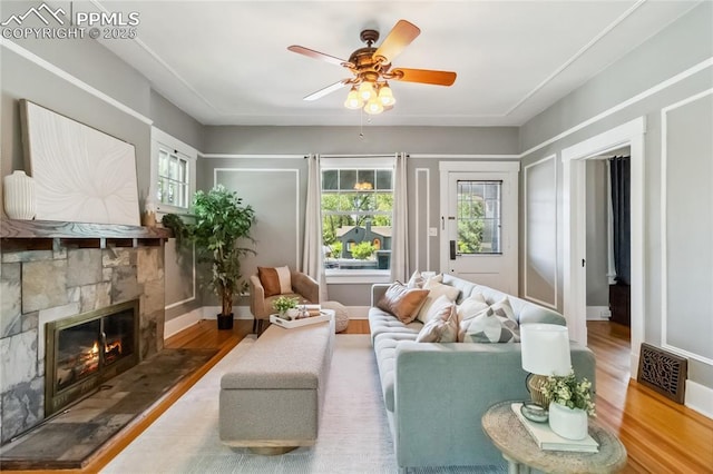 1326 E Platte Ave, Colorado Springs, CO 80909 - living area featuring wood finished floors, ceiling fan, and a stone fireplace