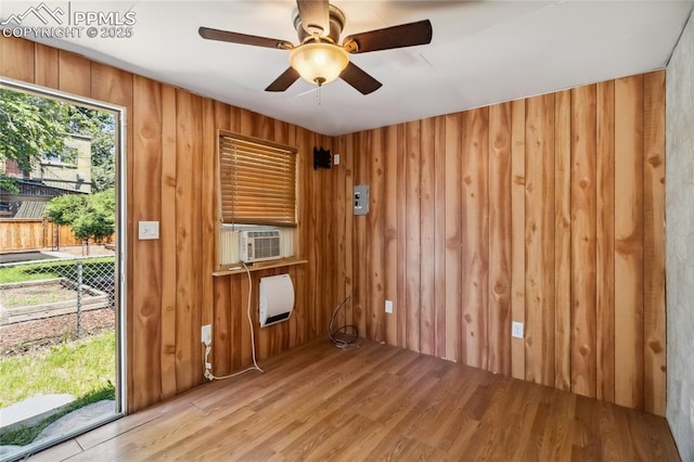 1326 E Platte Ave, Colorado Springs, CO 80909 - spare room featuring wood finished floors, wood walls, ceiling fan, and cooling unit