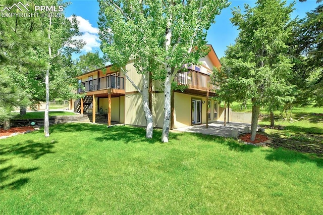 19235 Wakonda Way, Monument, CO 80132 - rear view of house featuring a wooden deck, a lawn, a patio, and stairs