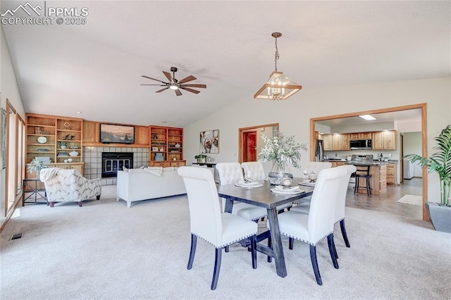 19235 Wakonda Way, Monument, CO 80132 - dining room with vaulted ceiling, a ceiling fan, a tile fireplace, and light carpet