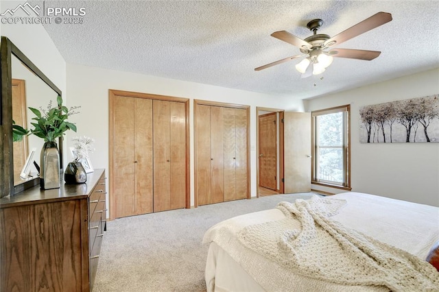 19235 Wakonda Way, Monument, CO 80132 - bedroom featuring light carpet, multiple closets, a ceiling fan, and a textured ceiling