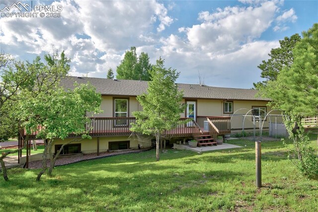 19235 Wakonda Way, Monument, CO 80132 - back of property featuring a wooden deck, a lawn, a shingled roof, and stucco siding