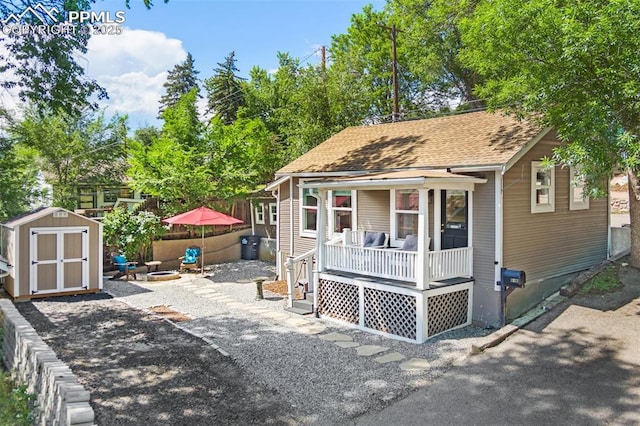 112 N 12th St, Colorado Springs, CO 80904 - view of front of property with a storage unit, a porch, a shingled roof, and an outdoor fire pit