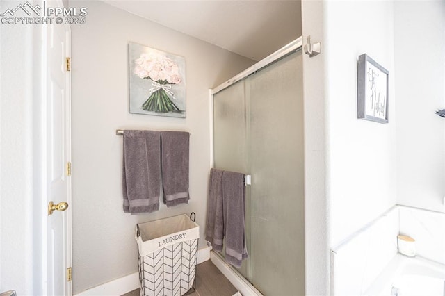 11310 Falling Star Rd, Fountain, CO 80817 - bathroom with a shower stall, a tub, and wood finished floors