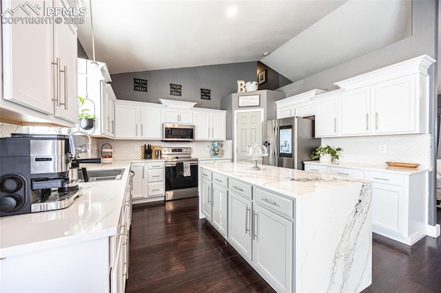 11310 Falling Star Rd, Fountain, CO 80817 - kitchen with appliances with stainless steel finishes, white cabinets, a center island, backsplash, and high vaulted ceiling