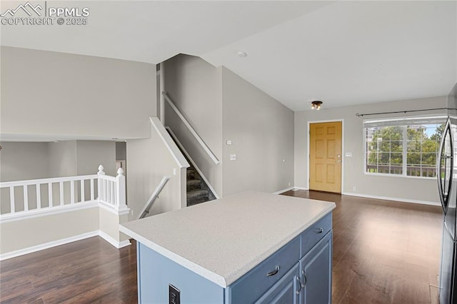 9344 Hirono Rd, Peyton, CO 80831 - kitchen featuring blue cabinets, lofted ceiling, dark wood-style flooring, open floor plan, and light countertops