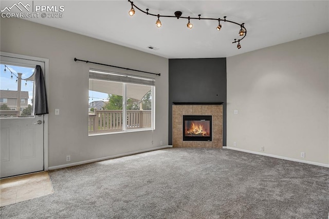 9344 Hirono Rd, Peyton, CO 80831 - unfurnished living room featuring carpet floors, plenty of natural light, and a tile fireplace