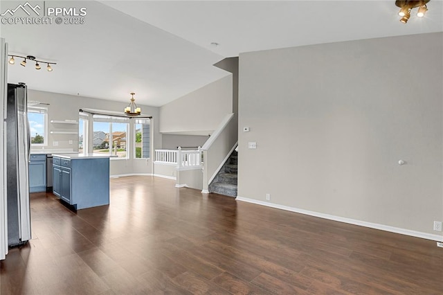 9344 Hirono Rd, Peyton, CO 80831 - unfurnished living room with a chandelier, dark wood-style floors, stairs, and rail lighting