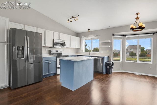 9344 Hirono Rd, Peyton, CO 80831 - kitchen featuring appliances with stainless steel finishes, vaulted ceiling, light countertops, dark wood-style flooring, and white cabinetry