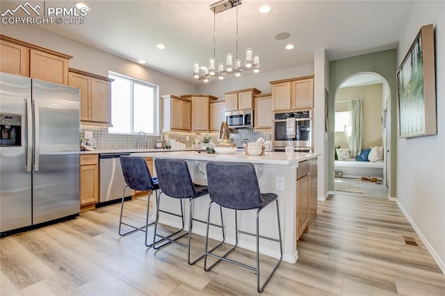 9656 Feathergrass Dr, Colorado Springs, CO 80927 - kitchen with appliances with stainless steel finishes, light brown cabinets, decorative backsplash, a kitchen bar, and recessed lighting