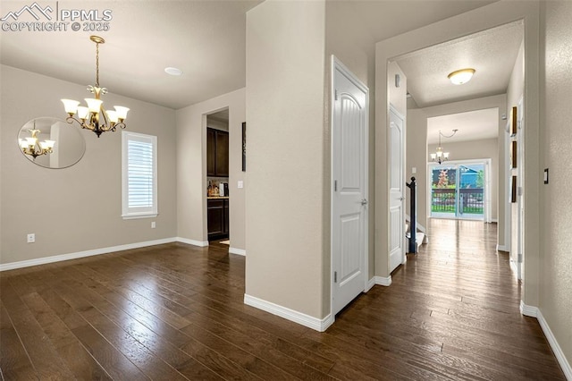 6808 Black Saddle Dr, Colorado Springs, CO 80924 - hall featuring a chandelier and dark wood-style floors